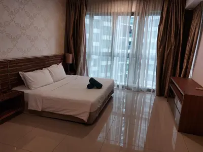 a bedroom with a bed with a black hat on it at KLCC Regalia Suites Infinity Pool Kuala Lumpur in Kuala Lumpur