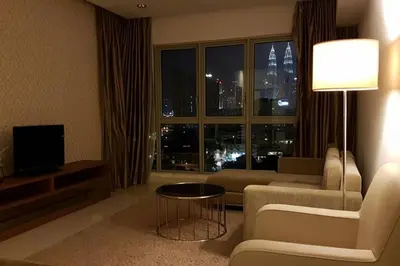 a living room with a couch and a tv and a window at KLCC Regalia Suites Infinity Pool Kuala Lumpur in Kuala Lumpur