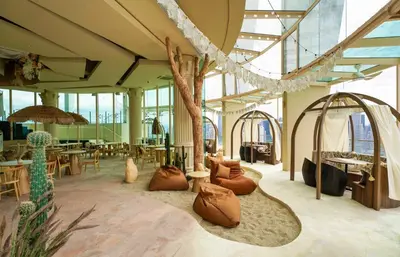 a large room with tables and chairs and a tree at Regalia Suites Infinity Pool Kuala Lumpur in Kuala Lumpur