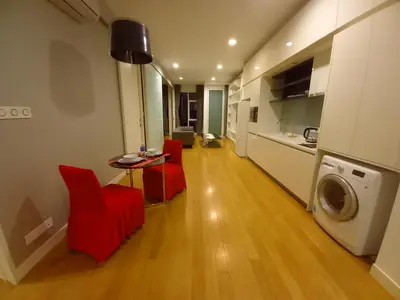 a living room with red chairs and a table and a washing machine at Yemala Suites at Platinum KLCC in Kuala Lumpur