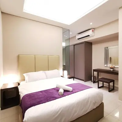 a bedroom with a large bed and a desk at Dorsett Residences Kuala Lumpur in Kuala Lumpur
