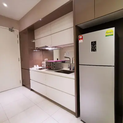 a kitchen with a white refrigerator and a sink at Dorsett Residences Kuala Lumpur in Kuala Lumpur