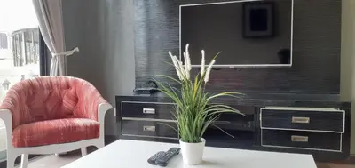 a living room with a tv and a chair and a table at Omar's Place 2 in Kuala Lumpur