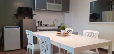 a kitchen with a white table and chairs and a refrigerator at Omar's Place 2 in Kuala Lumpur