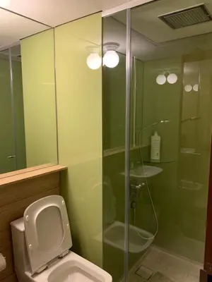 a bathroom with a toilet and a glass shower at KLCC City SkySuites in Kuala Lumpur