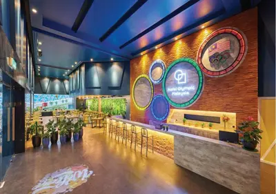 a restaurant with a bar with tables and chairs at Hotel Olympic Malaysia Kuala Lumpur in Kuala Lumpur