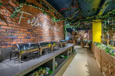 a row of benches against a brick wall with plants at Hotel Olympic Malaysia Kuala Lumpur in Kuala Lumpur