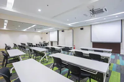 an empty classroom with tables and chairs and a whiteboard at Hotel Olympic Malaysia Kuala Lumpur in Kuala Lumpur
