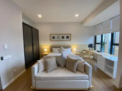 a bedroom with a white bed and a white couch at Ceylonz Lifestyle Suites @ Bukit Bintang in Kuala Lumpur