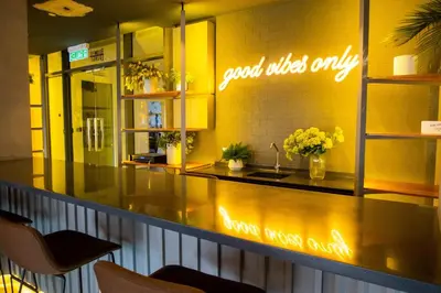 a restaurant with a counter with a sign on the wall at Ceylonz Suites KLCC Rooftop Infinity Pool KL Tower View in Kuala Lumpur