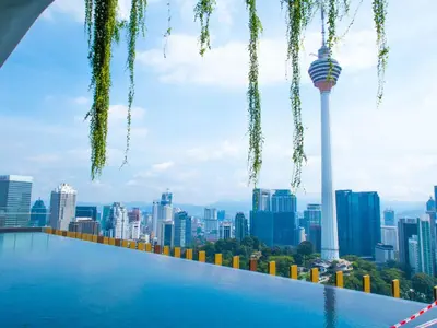 a swimming pool with a city skyline in the background at Ceylonz Suites KLCC Rooftop Infinity Pool KL Tower View in Kuala Lumpur