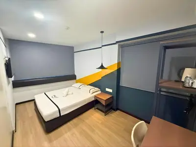 a small room with a bed and a table at Smile Hotel Chow Kit PWTC in Kuala Lumpur