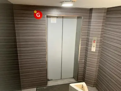 a elevator in a building with a sign on the wall at Smile Hotel Chow Kit PWTC in Kuala Lumpur