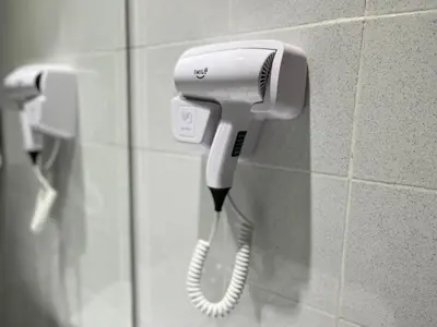 a white hair dryer hanging on a wall at Smile Hotel Chow Kit PWTC in Kuala Lumpur