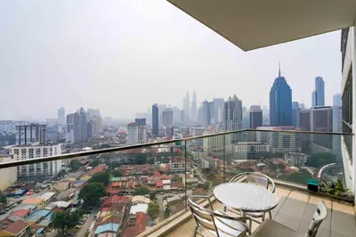 a balcony with two chairs and a view of a city at Regalia Residence KLCC View by iLuxHome in Kuala Lumpur