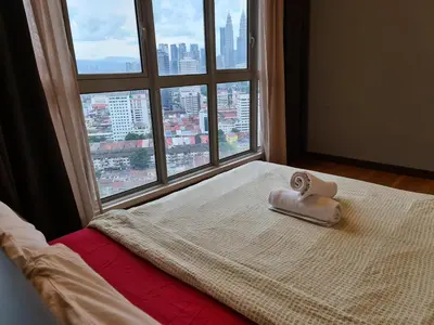 a bed with a towel on it in front of a window at Regalia Residence KLCC View by iLuxHome in Kuala Lumpur
