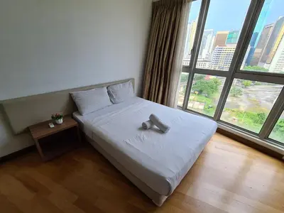 a bed in a room with a large window at Regalia Residence KLCC View by iLuxHome in Kuala Lumpur