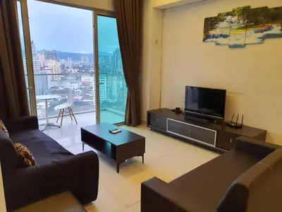 a living room with a couch and a flat screen tv at Regalia Residence KLCC View by iLuxHome in Kuala Lumpur