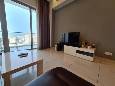 a living room with a tv and a large window at Regalia Residence KLCC View by iLuxHome in Kuala Lumpur