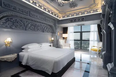a bedroom with a white bed and a blue wall at arte by Thomas Chan in Kuala Lumpur