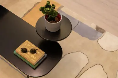 a table with a potted plant and a book at AMI Suites - Arte Mont Kiara in Kuala Lumpur
