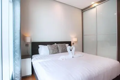 two swans sitting on a bed in a bedroom at Soho Suites KLCC by GuestHouse in Kuala Lumpur