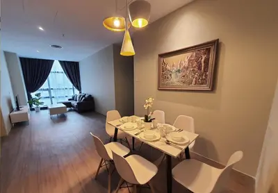 a dining room with a table and white chairs at Bangsar Trade Centre Kuala Lumpur by SkyLimit Suites in Kuala Lumpur