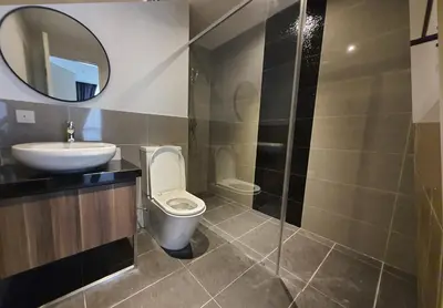 a bathroom with a toilet and a sink and a mirror at Bangsar Trade Centre Kuala Lumpur by SkyLimit Suites in Kuala Lumpur