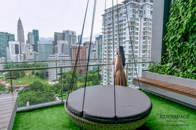 a woman is sitting in a swing on a balcony at Ceylonz Suites by EdenZpace in Kuala Lumpur