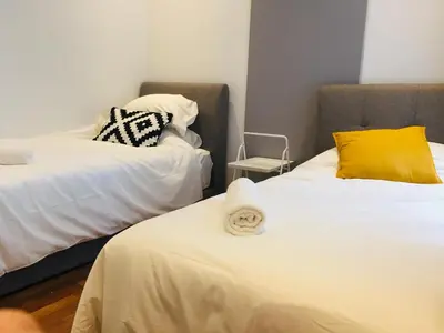 a room with two beds and a chair at KLGateway Premium Residence Mid Valley in Kuala Lumpur