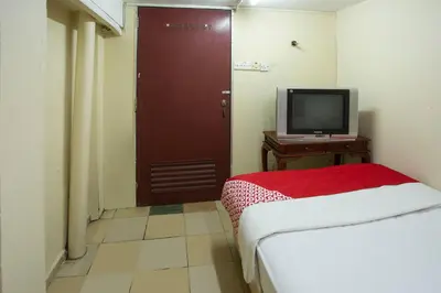 a room with a bed and a tv and a door at SPOT ON 90137 Casavilla Hotel Pudu in Kuala Lumpur