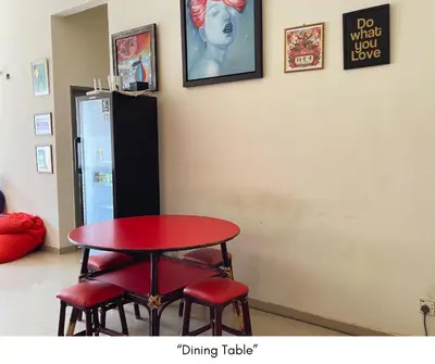 a red table and four red stools in a room at Monkey Mansion in Kuala Lumpur