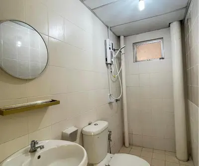 a bathroom with a toilet and a sink and a mirror at Monkey Mansion in Kuala Lumpur