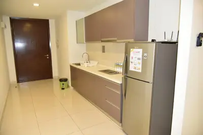 a kitchen with a refrigerator and a sink at Wonderful KLCC View at Regalia Suites in Kuala Lumpur