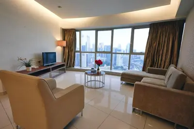 a living room with a couch and chairs and a television at Wonderful KLCC View at Regalia Suites in Kuala Lumpur