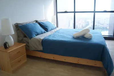 a bedroom with a bed with blue sheets and a night stand at M City Lake View 1+1 Room in Kuala Lumpur