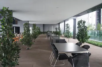 a cafeteria with tables and potted trees in a building at M City Lake View 1+1 Room in Kuala Lumpur