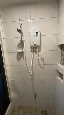 a shower in a bathroom with a phone on the wall at Arte Mont Kiara in Kuala Lumpur