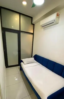 a small room with a blue couch and a fan at Arte Mont Kiara in Kuala Lumpur