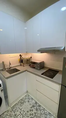 a kitchen with white cabinets and a sink at Arte Mont Kiara in Kuala Lumpur