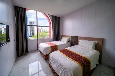 a hotel room with two beds and a window at Hotel LBS in Kuala Lumpur