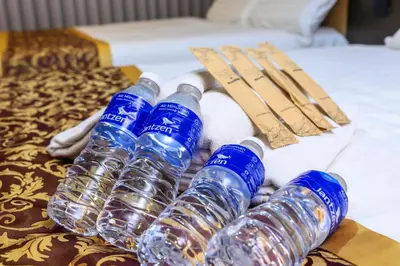 a group of water bottles sitting on a bed at Hotel LBS in Kuala Lumpur