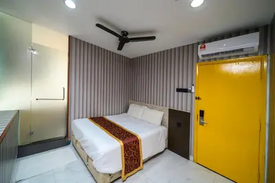 a yellow door in a room with a bed at Hotel LBS in Kuala Lumpur