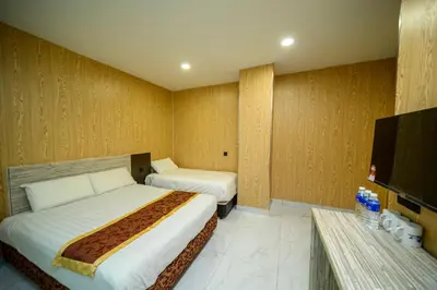 a hotel room with two beds and a flat screen tv at Hotel LBS in Kuala Lumpur