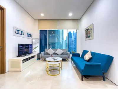 a living room with a blue couch and a tv at Soho Suites KLCC by Rest Kuala Lumpur in Kuala Lumpur