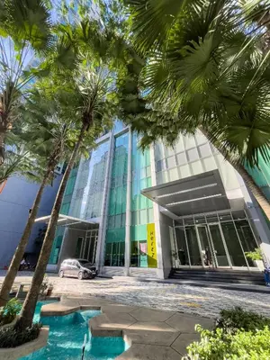 a building with palm trees in front of it at Soho Suites KLCC by Rest Kuala Lumpur in Kuala Lumpur