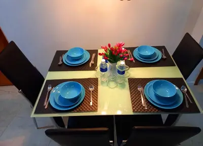 a dining table with blue dishes and flowers on it at Vortex KLCC Area in Kuala Lumpur