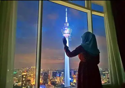 a woman standing in front of a window holding up a light bulb at Vortex KLCC Area in Kuala Lumpur