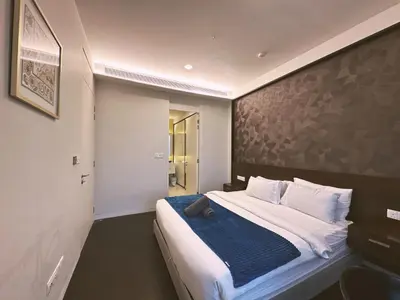 a bedroom with a large bed with a blue blanket at Tropicana The Residence By Klcc in Kuala Lumpur