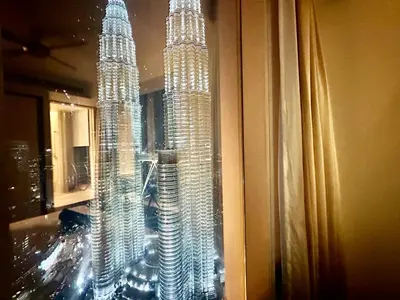 a model of the petronas towers is seen through a window at Tropicana The Residence By Klcc in Kuala Lumpur